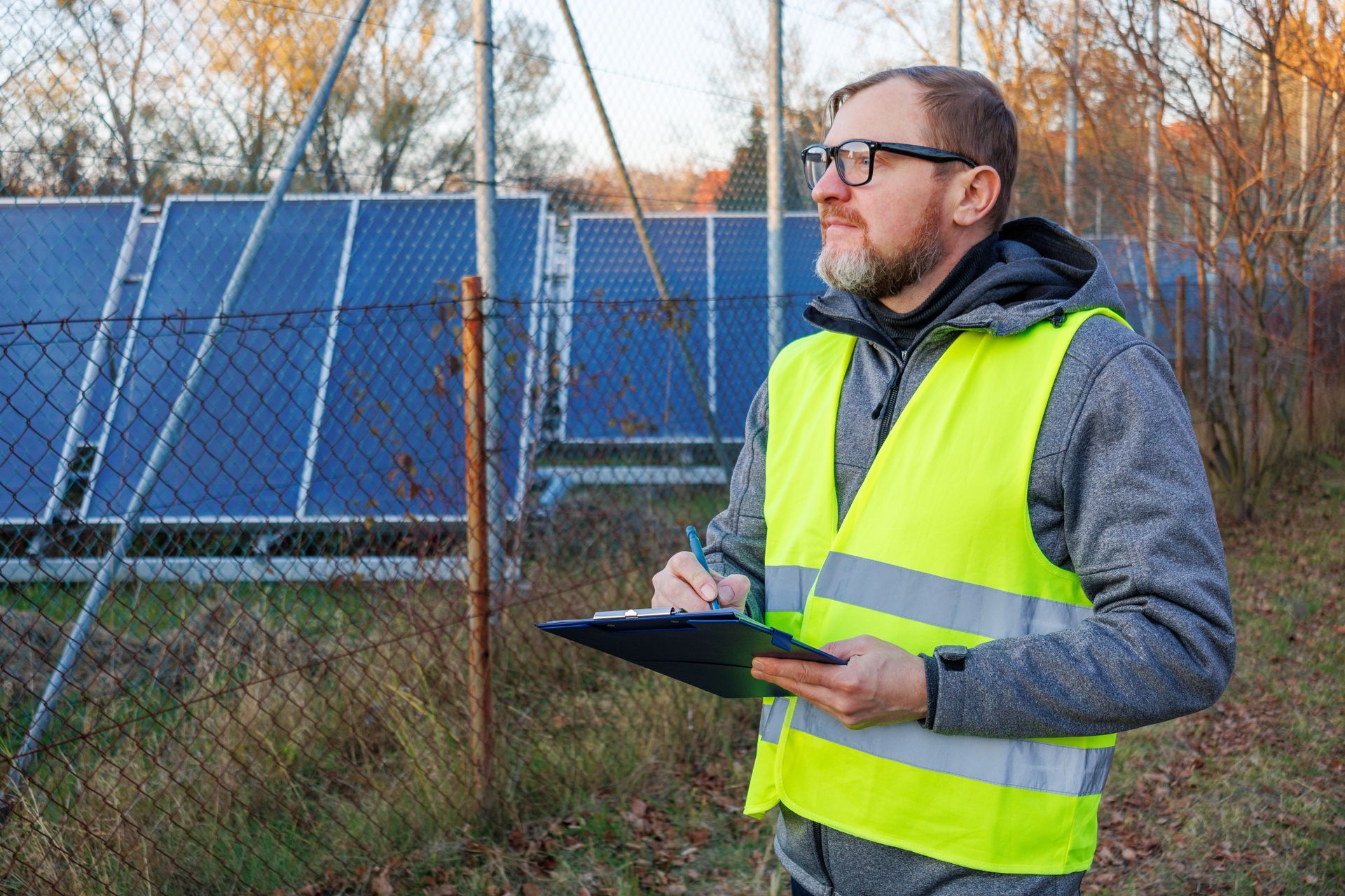 A Person in a High-visibility Vest Stands by a Chain-link Fence — Environment Restoration Solutions in Waterview Heights, NSW