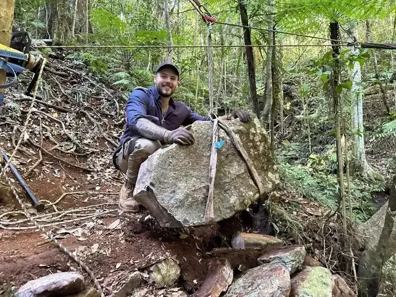 Person Hoisting a Large Stone With a Pulley System in a Forest — Environment Restoration Solutions in Waterview Heights, NSW