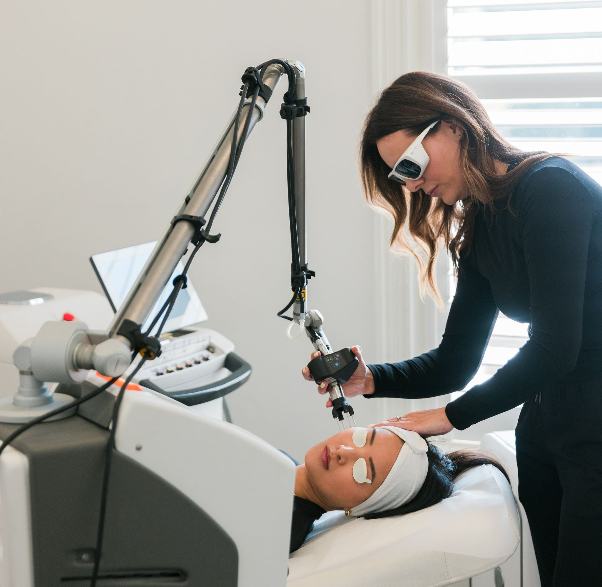 A woman is getting a laser treatment on her face.
