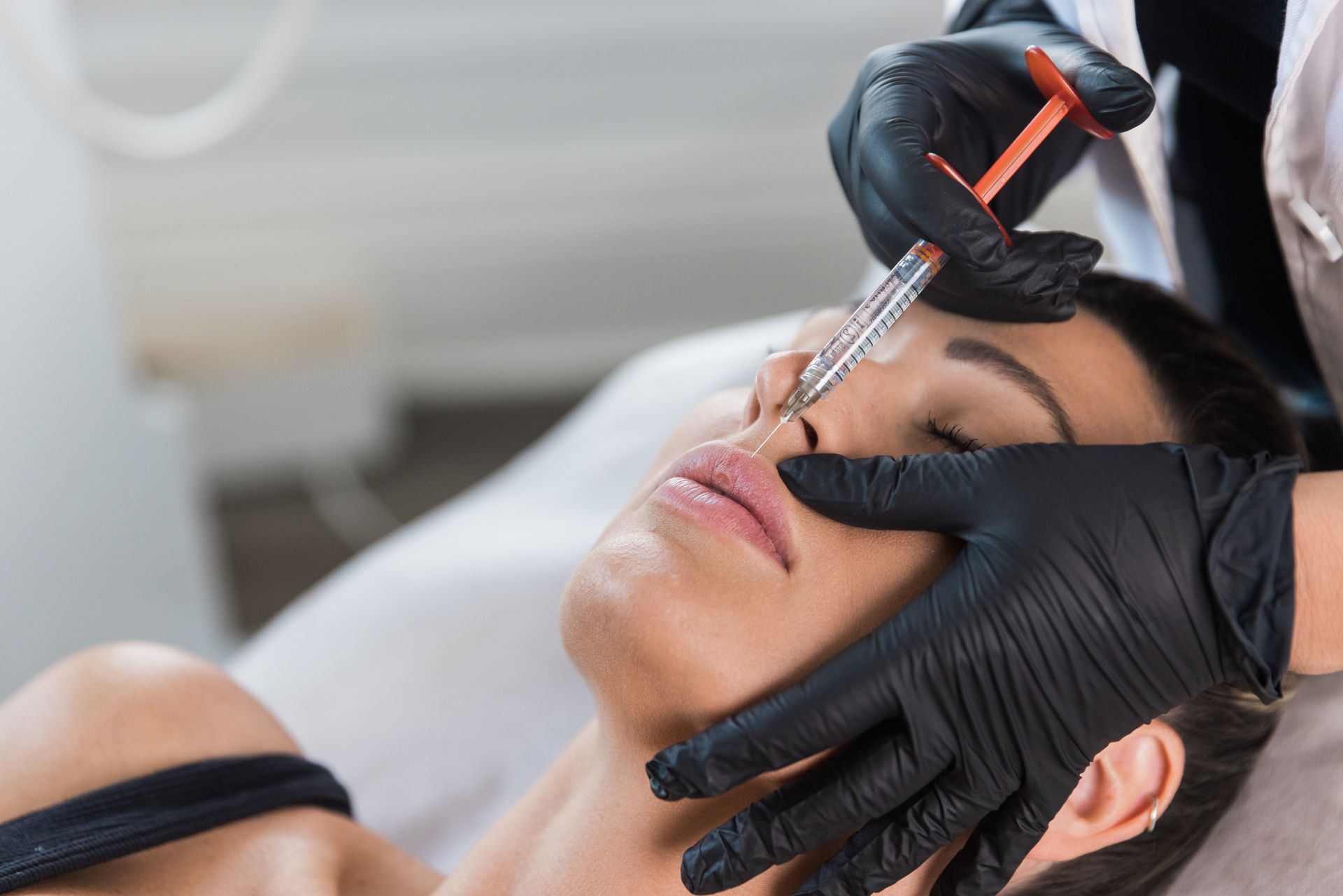 A woman is getting a botox injection in her nose.