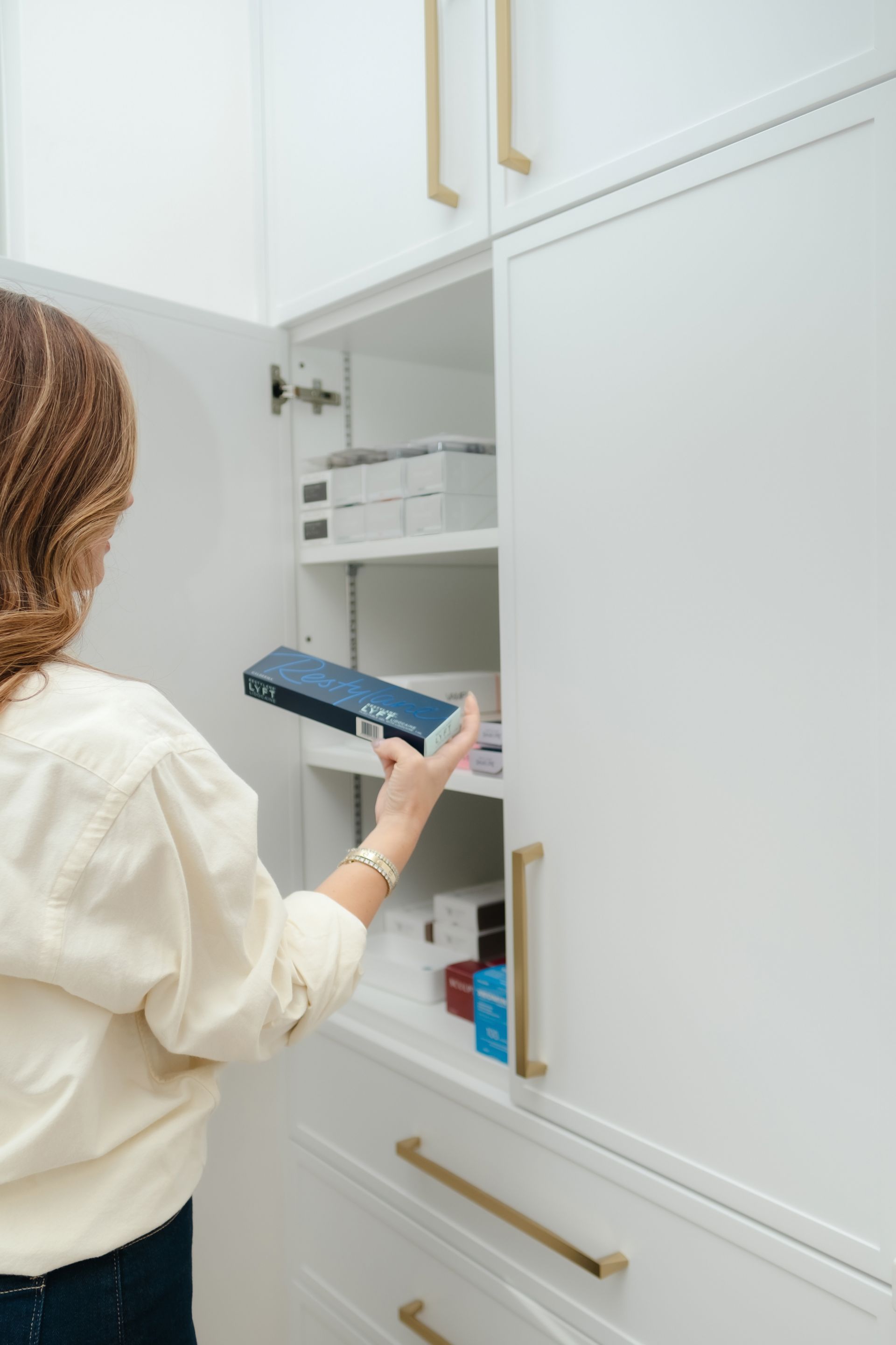Patient viewing natural-looking results of under eye restoration treatment in a handheld mirror.