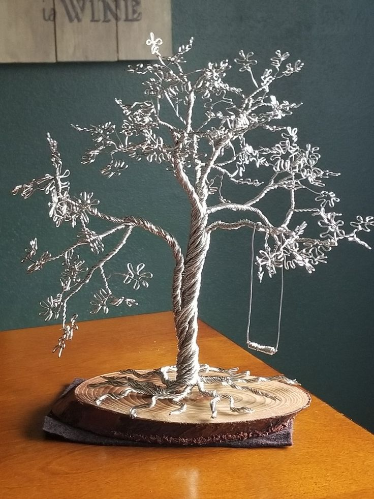 A sculpture of a tree with a swing attached to it