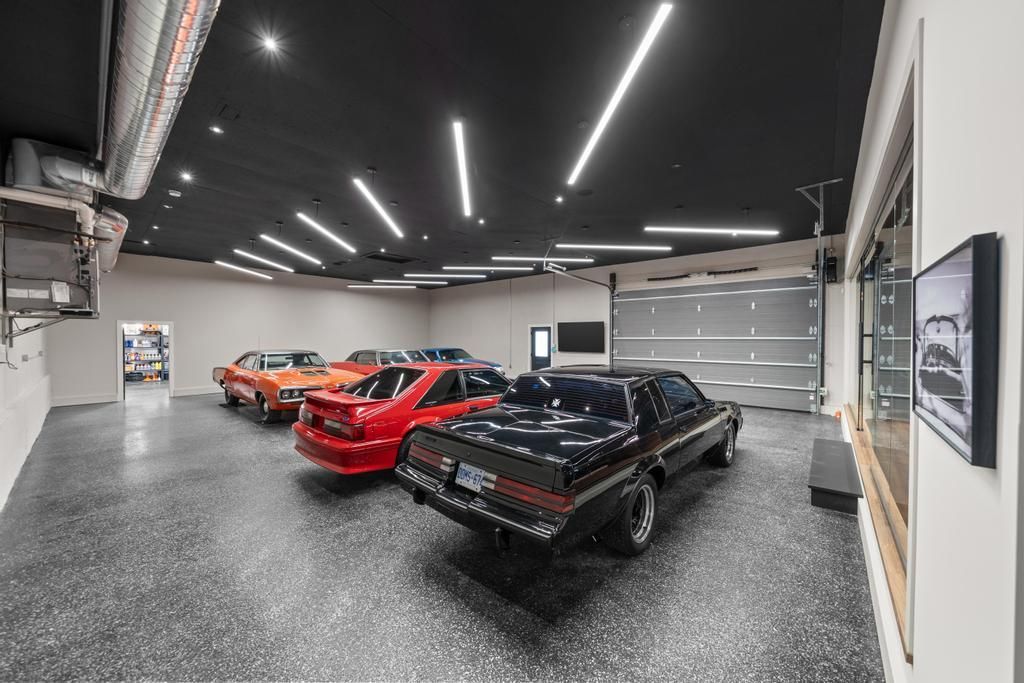 Three classic cars parked in a bright modern garage with black epoxy floor