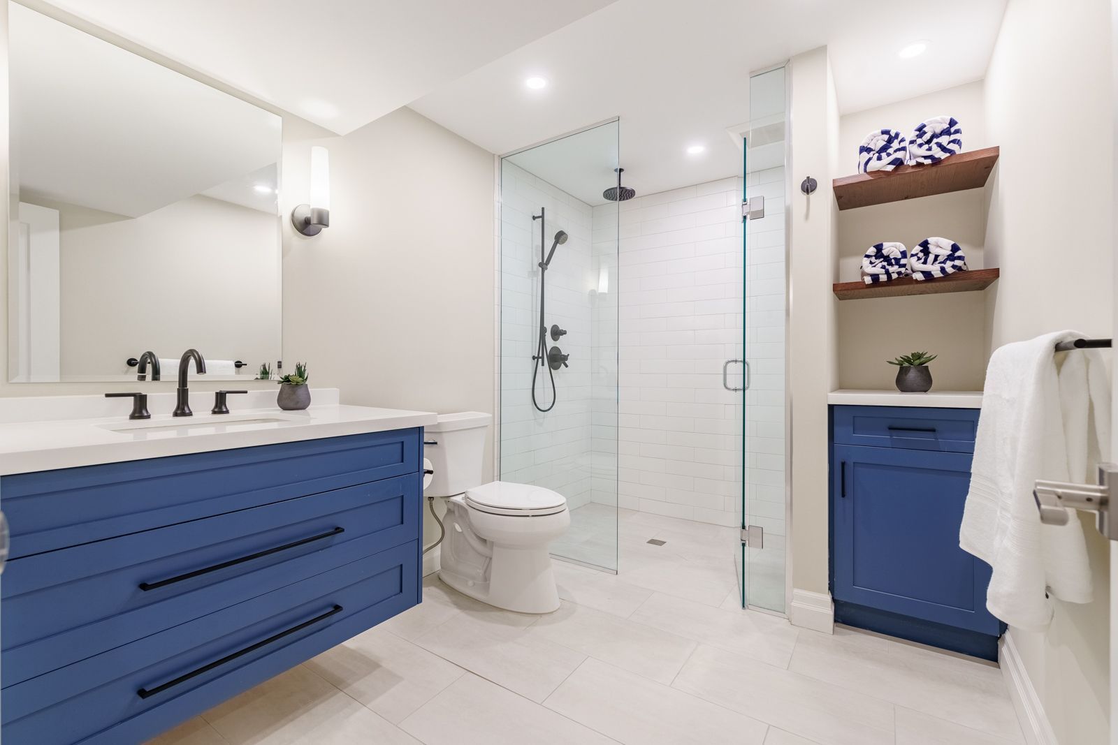 Bright modern bathroom with white walls, freestanding tub, wooden vanity, and large mirror