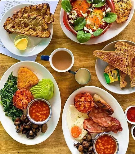 A table topped with plates of food and a cup of coffee.