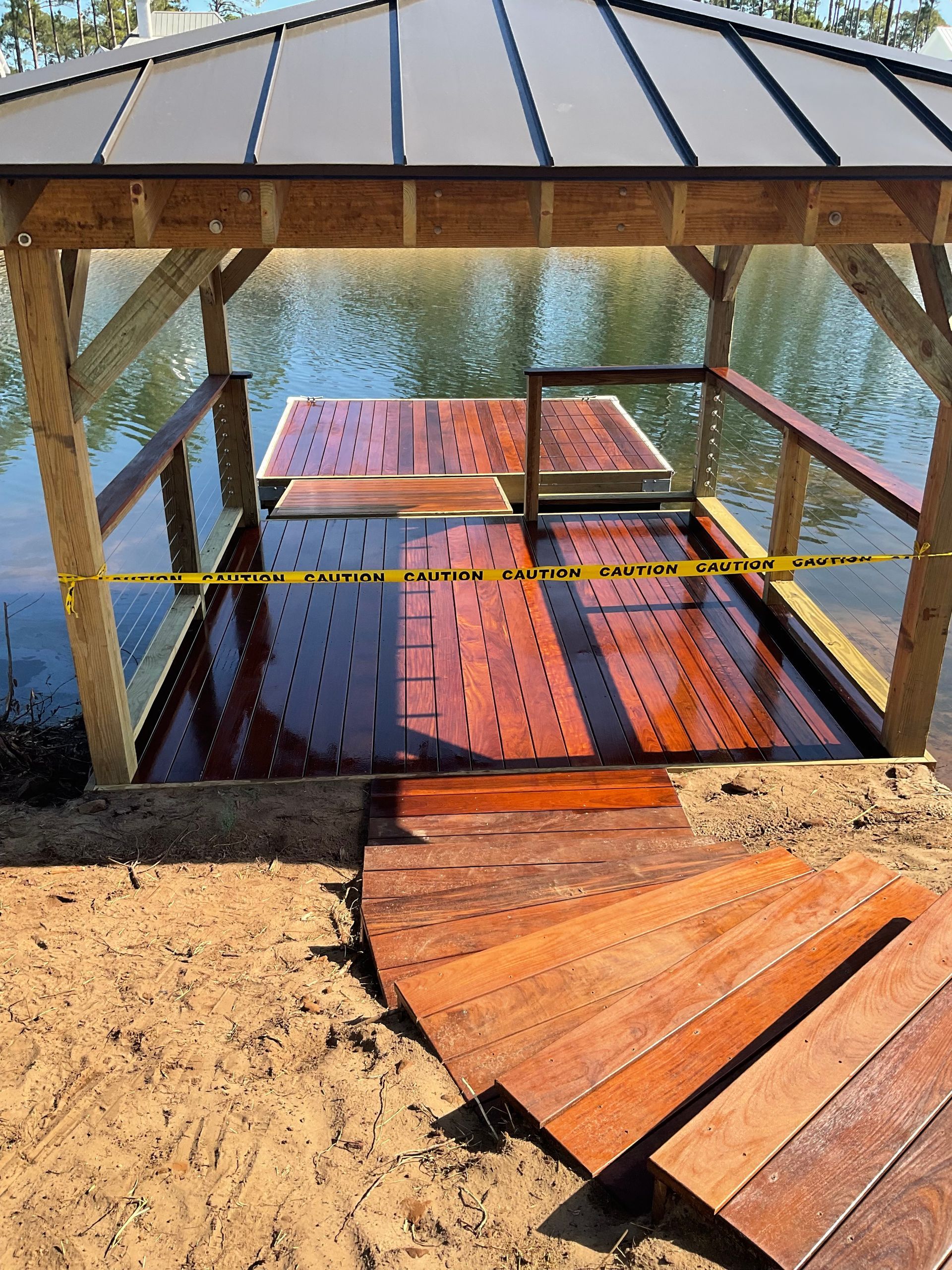A wooden gazebo is sitting in the middle of a body of water.