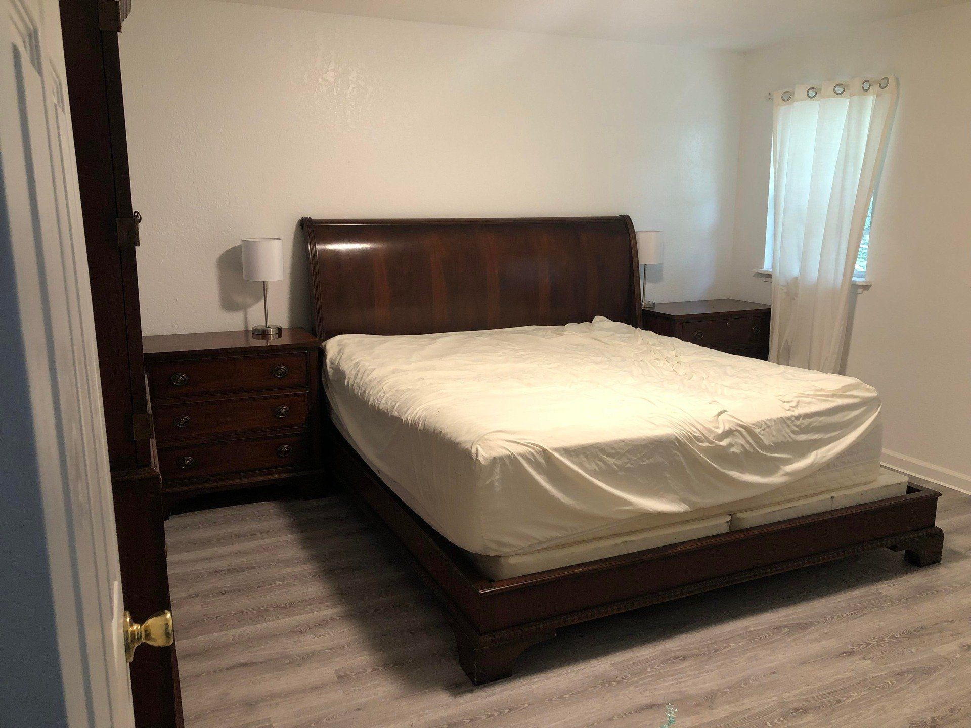 A bedroom with a king size bed , nightstands , and a window.