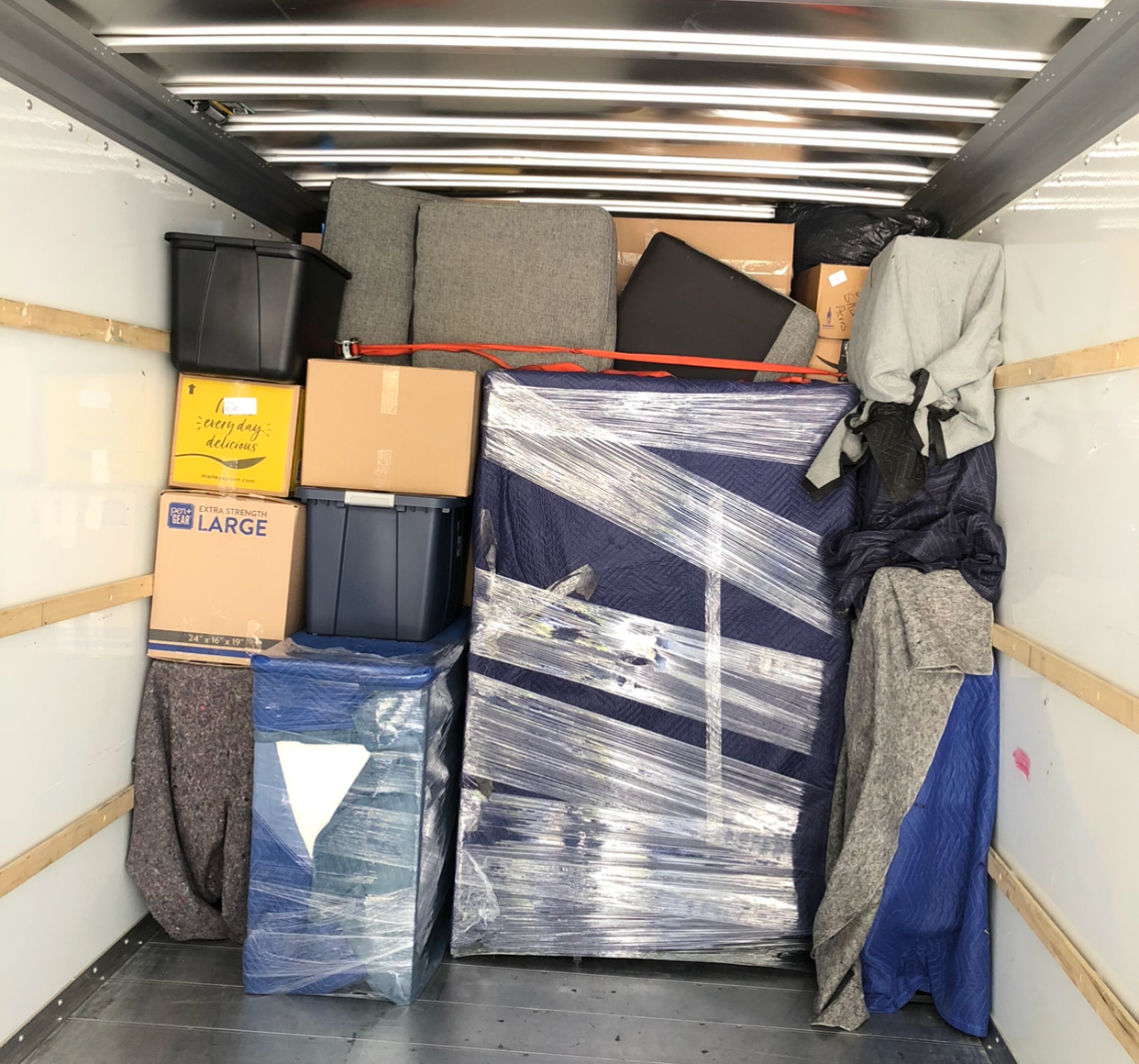 The inside of a moving truck filled with boxes including one that says abc