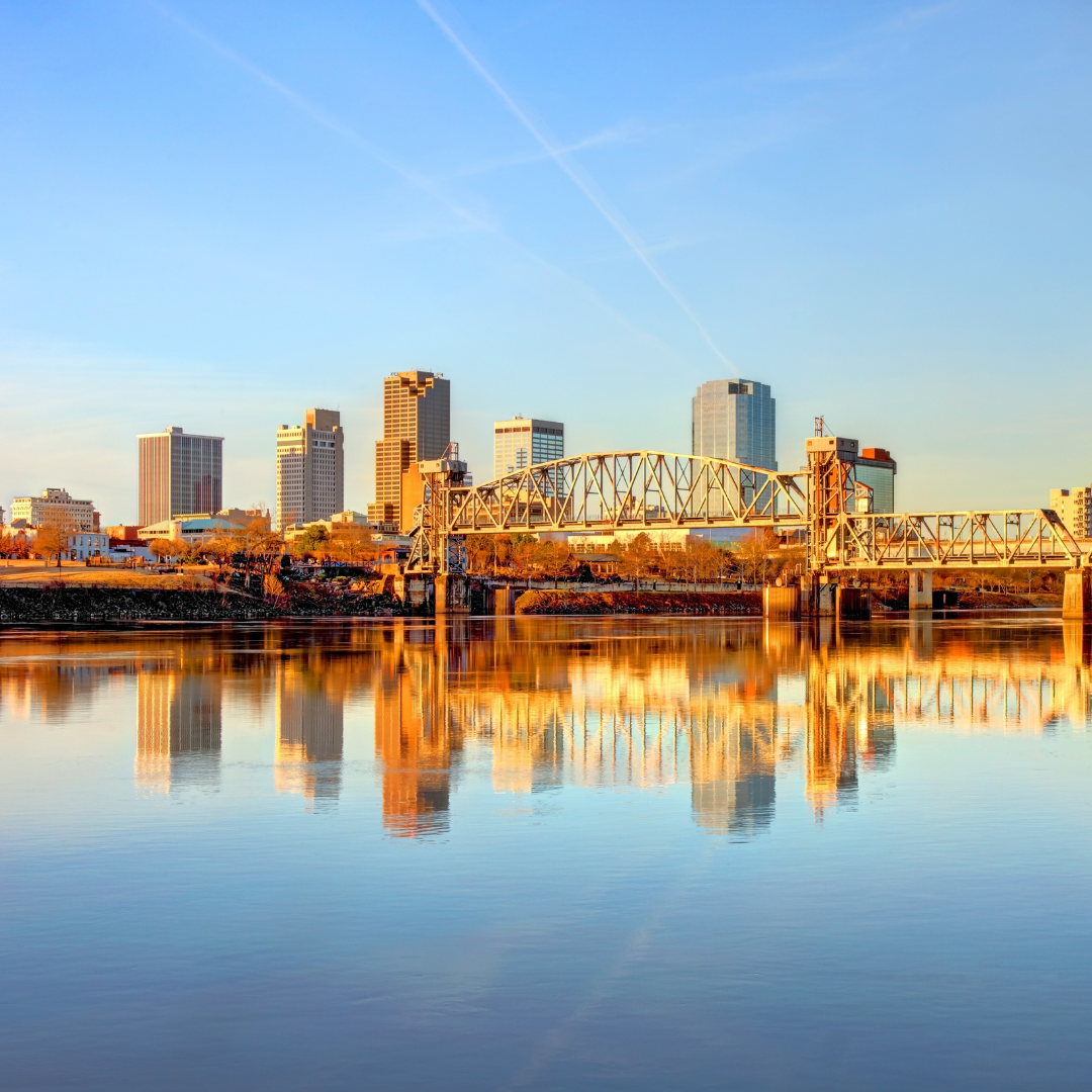 A city skyline is reflected in a body of water.