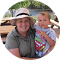 A woman in a hat is holding a baby in her arms.