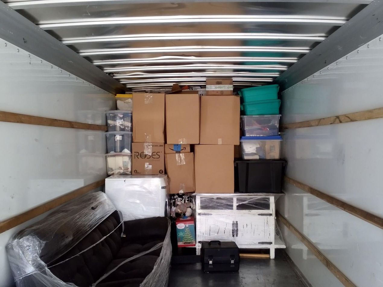 The inside of a moving truck filled with boxes and a couch