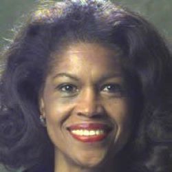 Portrait of a smiling woman with dark hair and bright red lipstick