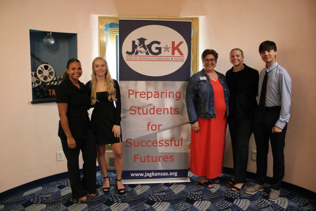 Five people stand beside a J&G-K banner reading “Preparing Students for Successful Futures.”