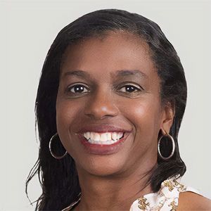 Smiling woman with hoop earrings against a light background