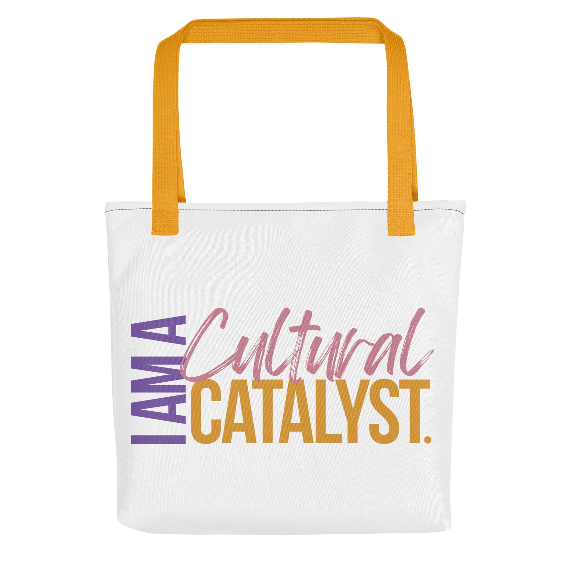White tote bag with orange handles and “I AM A Cultural CATALYST.” text in purple and pink.