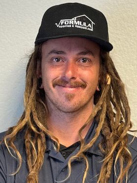 Man with dreadlocks and a mustache wearing a black hat with