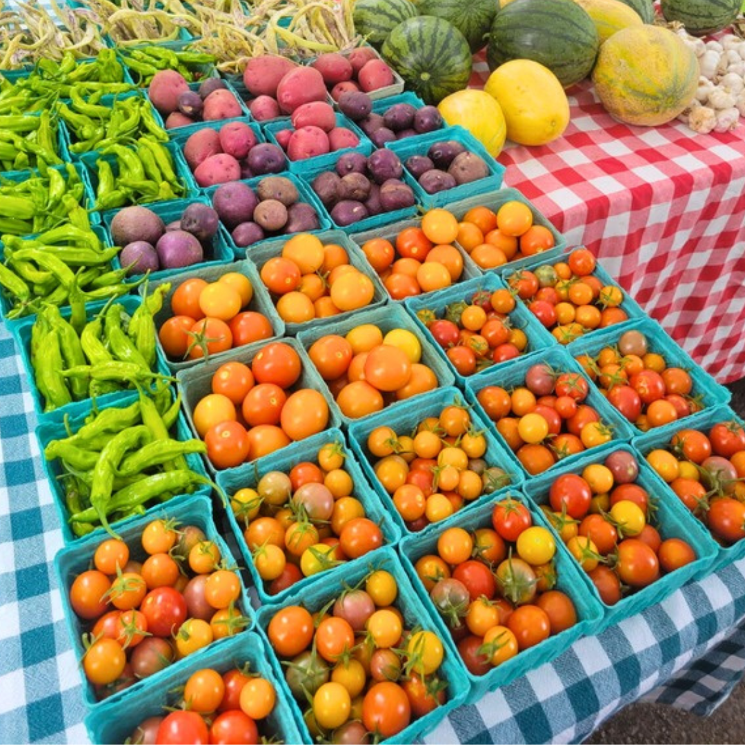 Colorful market display of fresh produce in crates on red and blue checkered tables