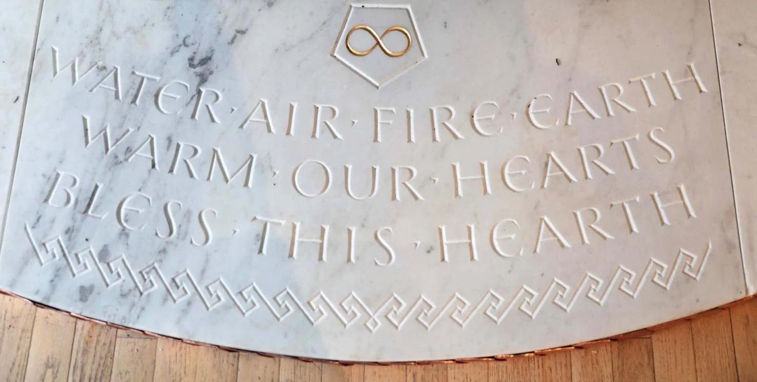 Engraved stone plaque with Latin text and a small infinity symbol at the top.