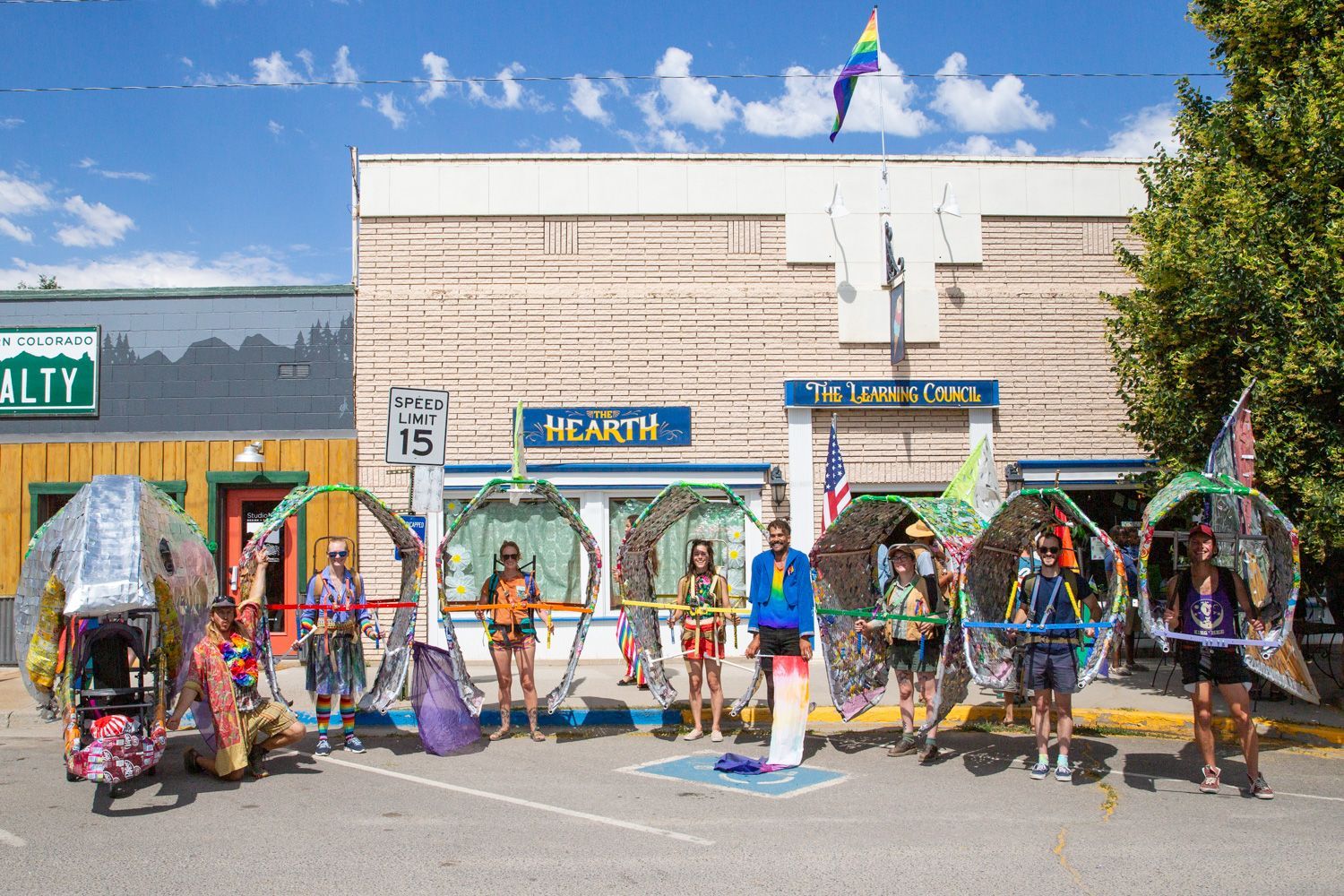 Colorful hula hoops and art displayed outside a storefront on a sunny street