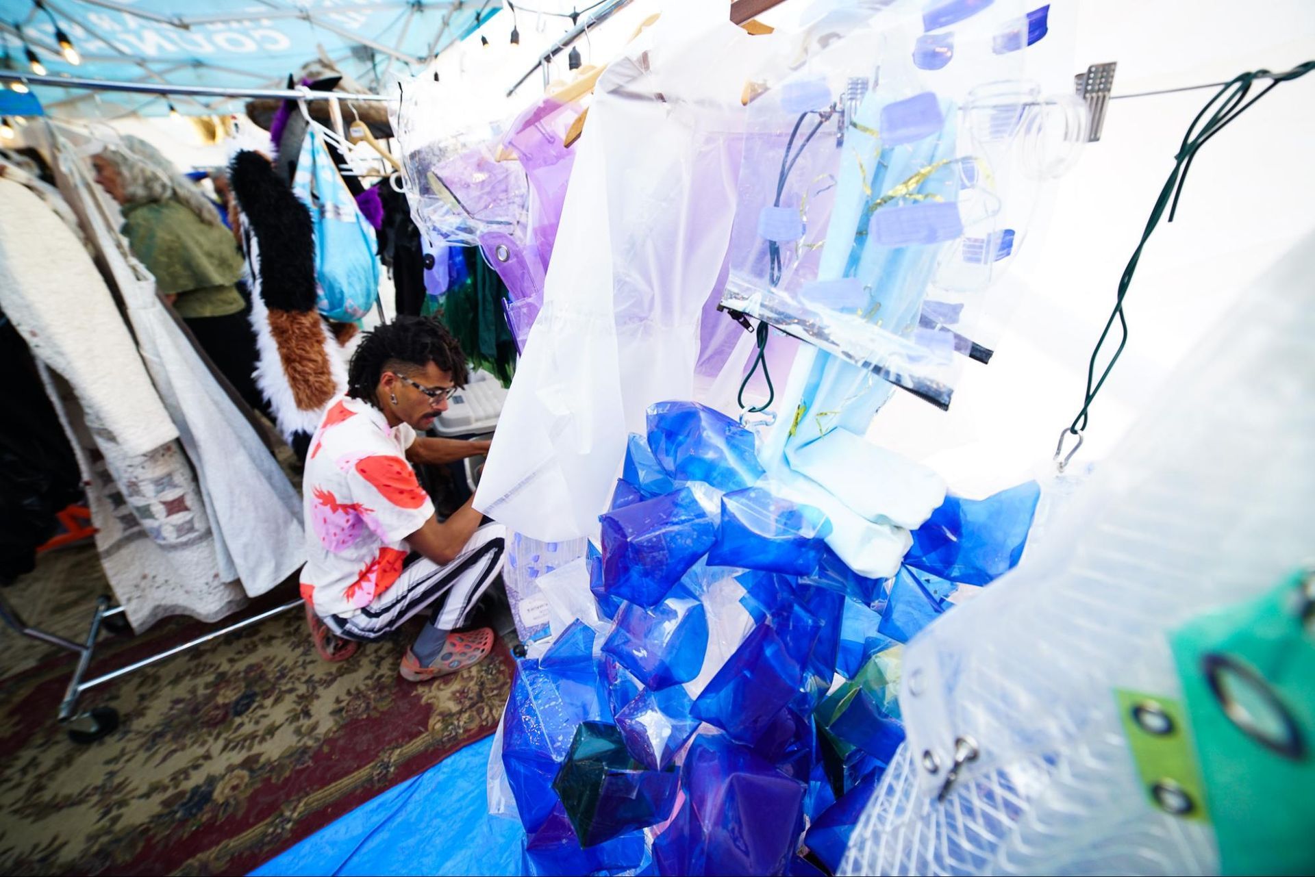 People viewing a colorful outdoor art installation with translucent blue and white panels