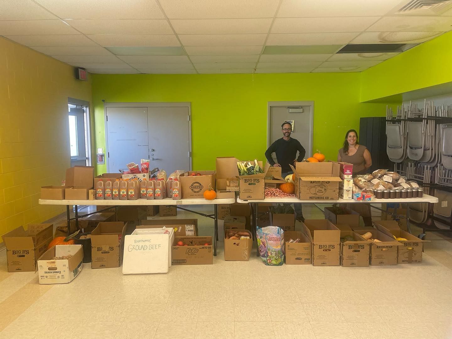 Donation table in a bright room with boxes and supplies stacked behind it