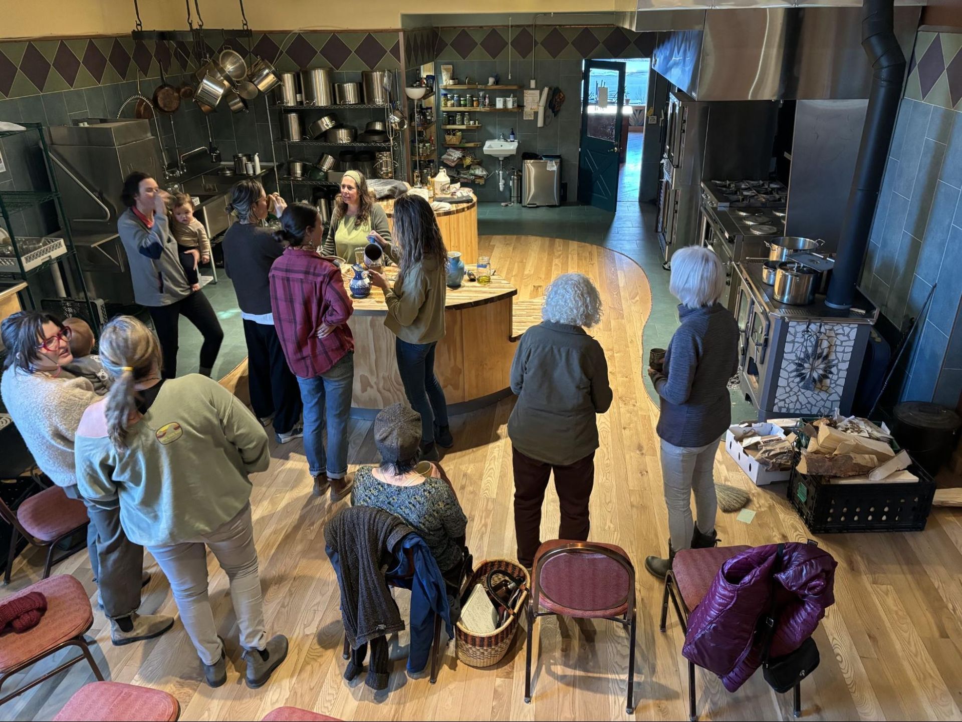 People gathered in a café, chatting near the counter and seating area.