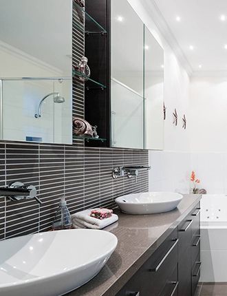 A bathroom with two sinks and a mirror above them