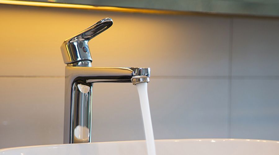 A bathroom sink with water running from a faucet.