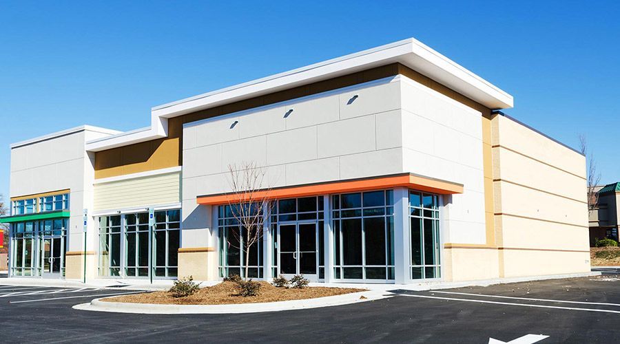 A large building with a lot of windows and a parking lot in front of it.