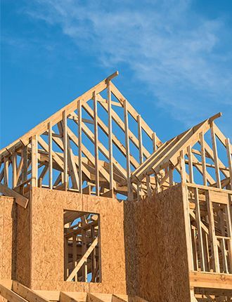 A house is being built with a blue sky in the background.