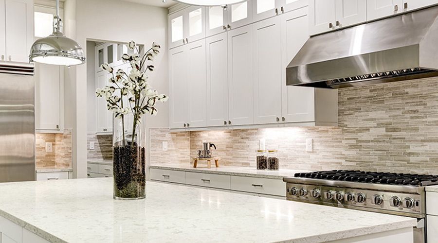 A kitchen with white cabinets and stainless steel appliances.