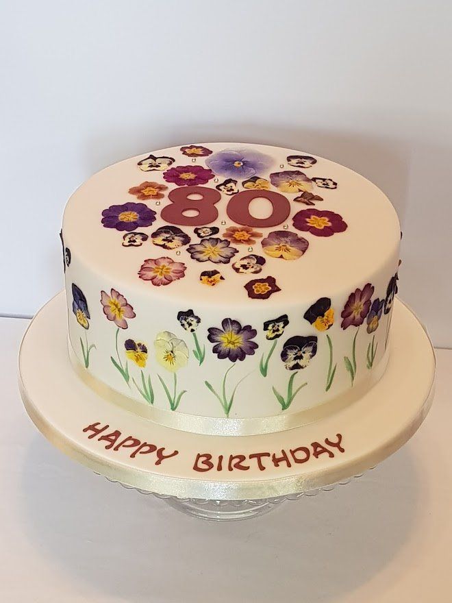 A birthday cake with flowers and the number 80 on it
