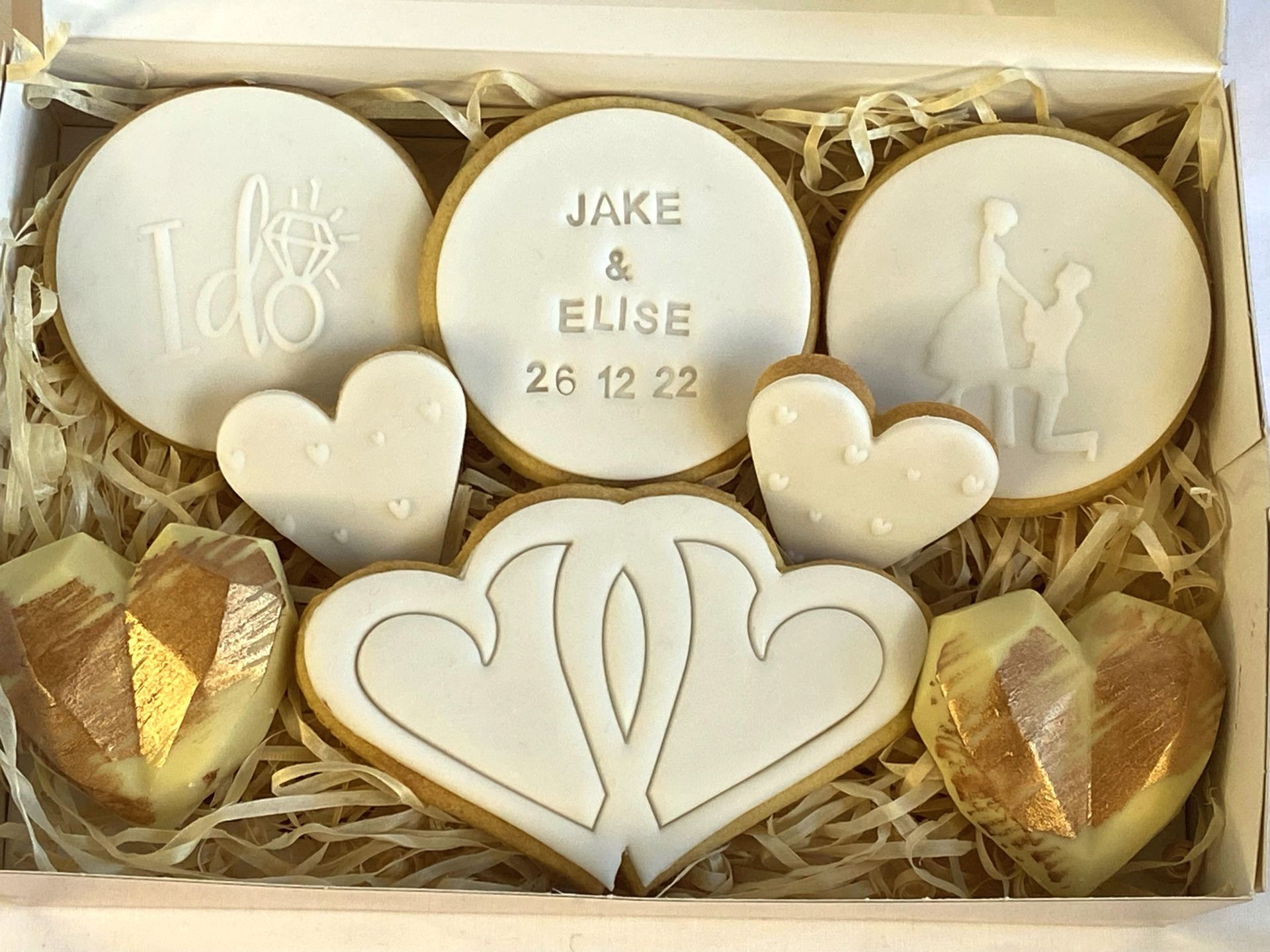 A box filled with wedding cookies and chocolate hearts.