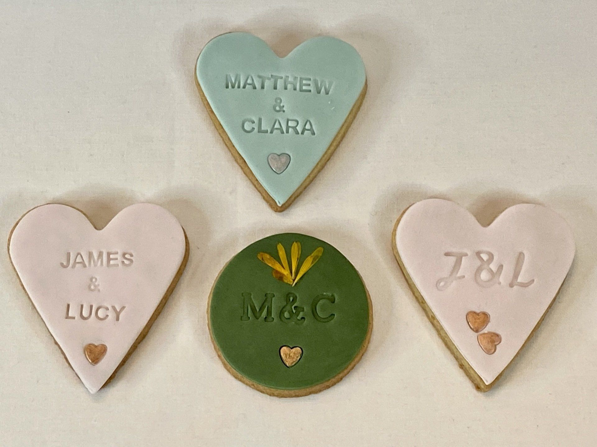 A group of heart shaped cookies with the names of james and lucy on them