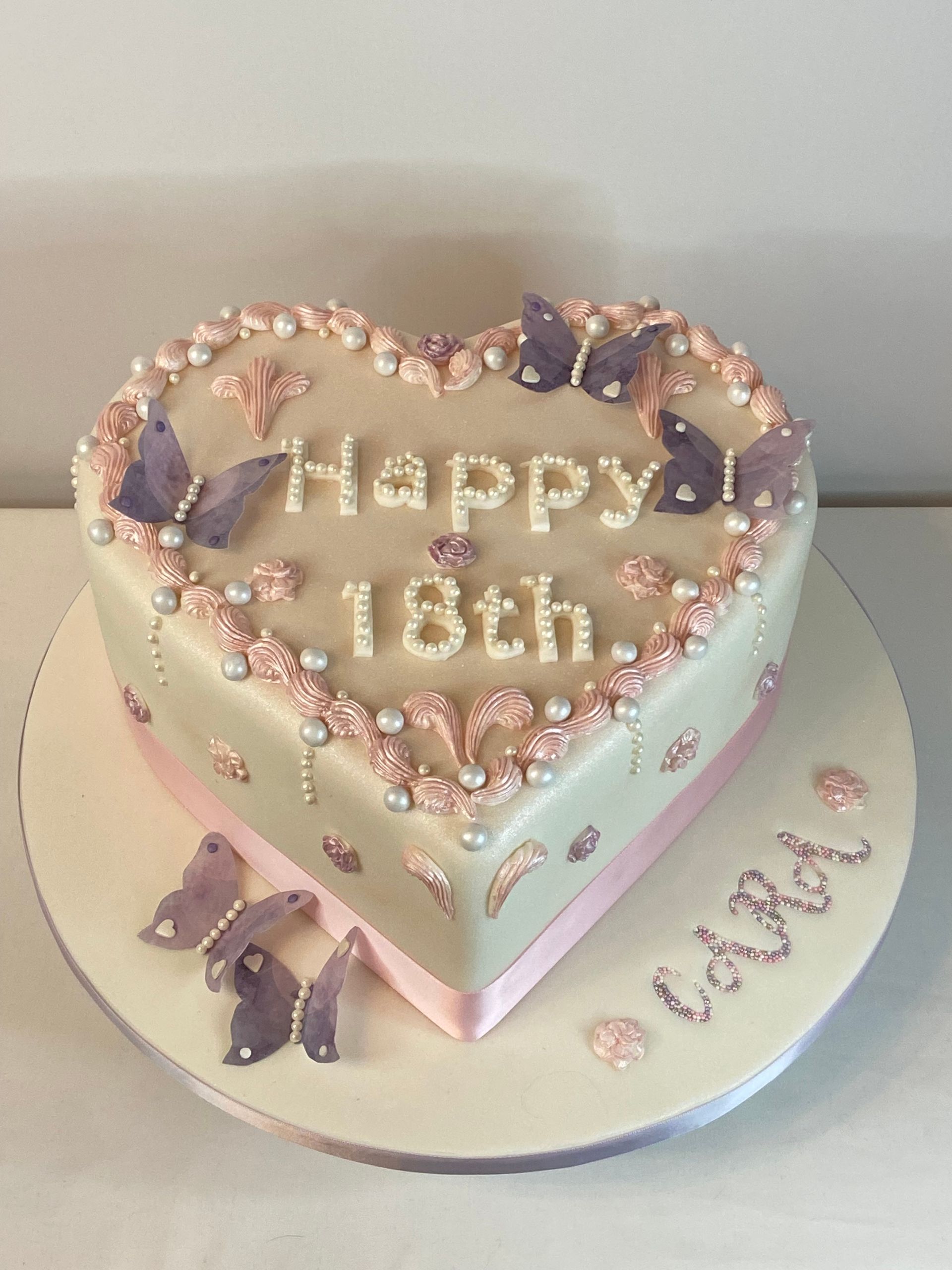 A heart shaped cake that says happy 18th on it
