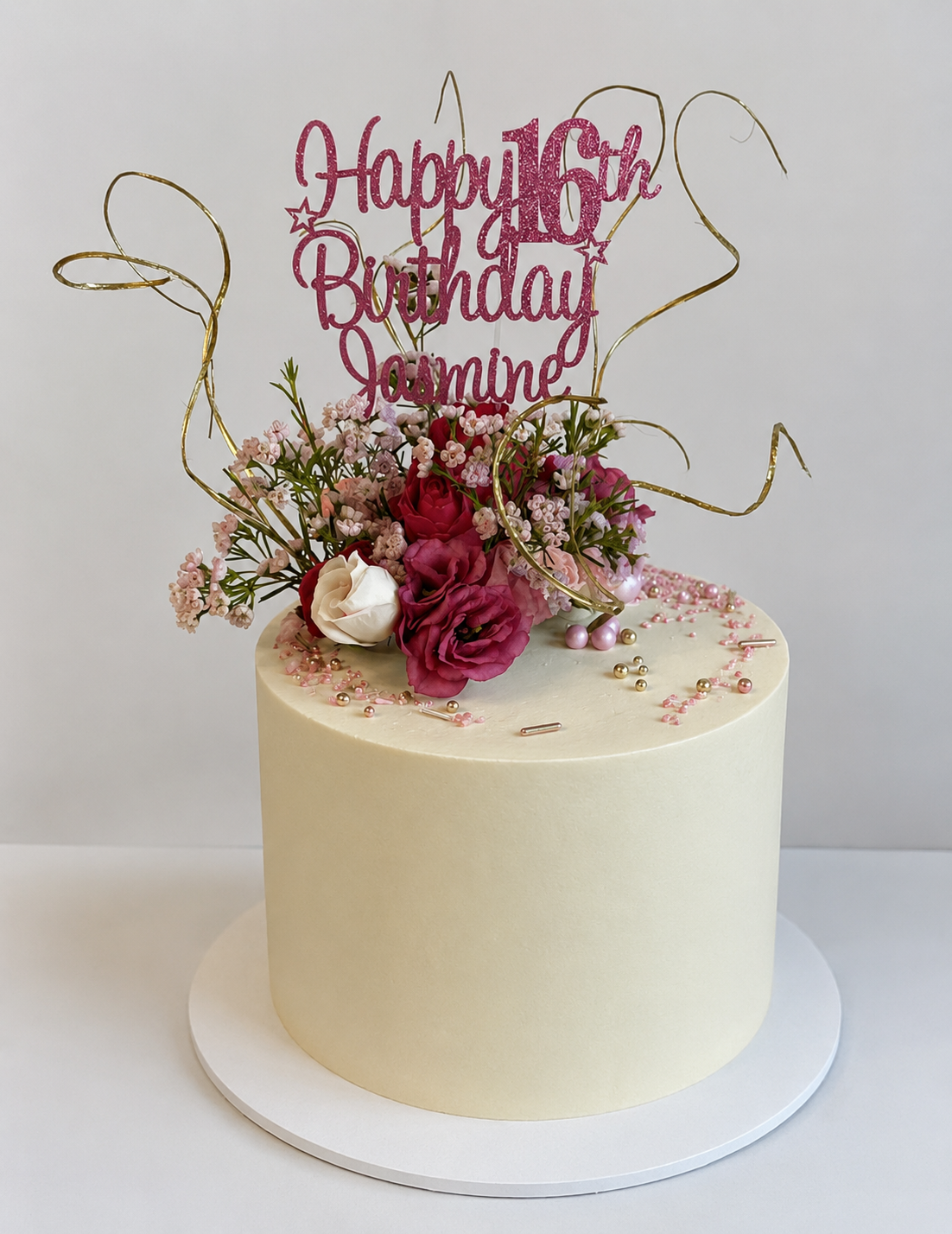 A white cake with yellow flowers on top is on a yellow plate.