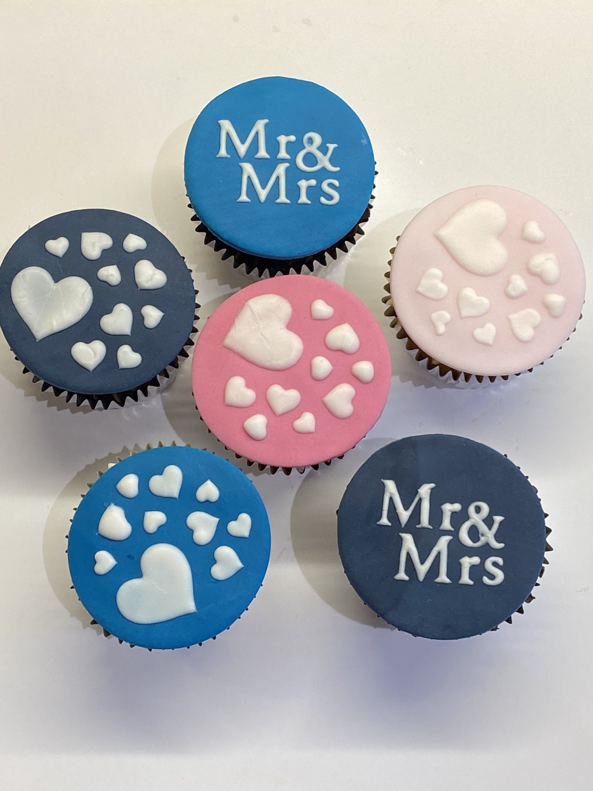 Six cupcakes with hearts and the words mr & mrs on them