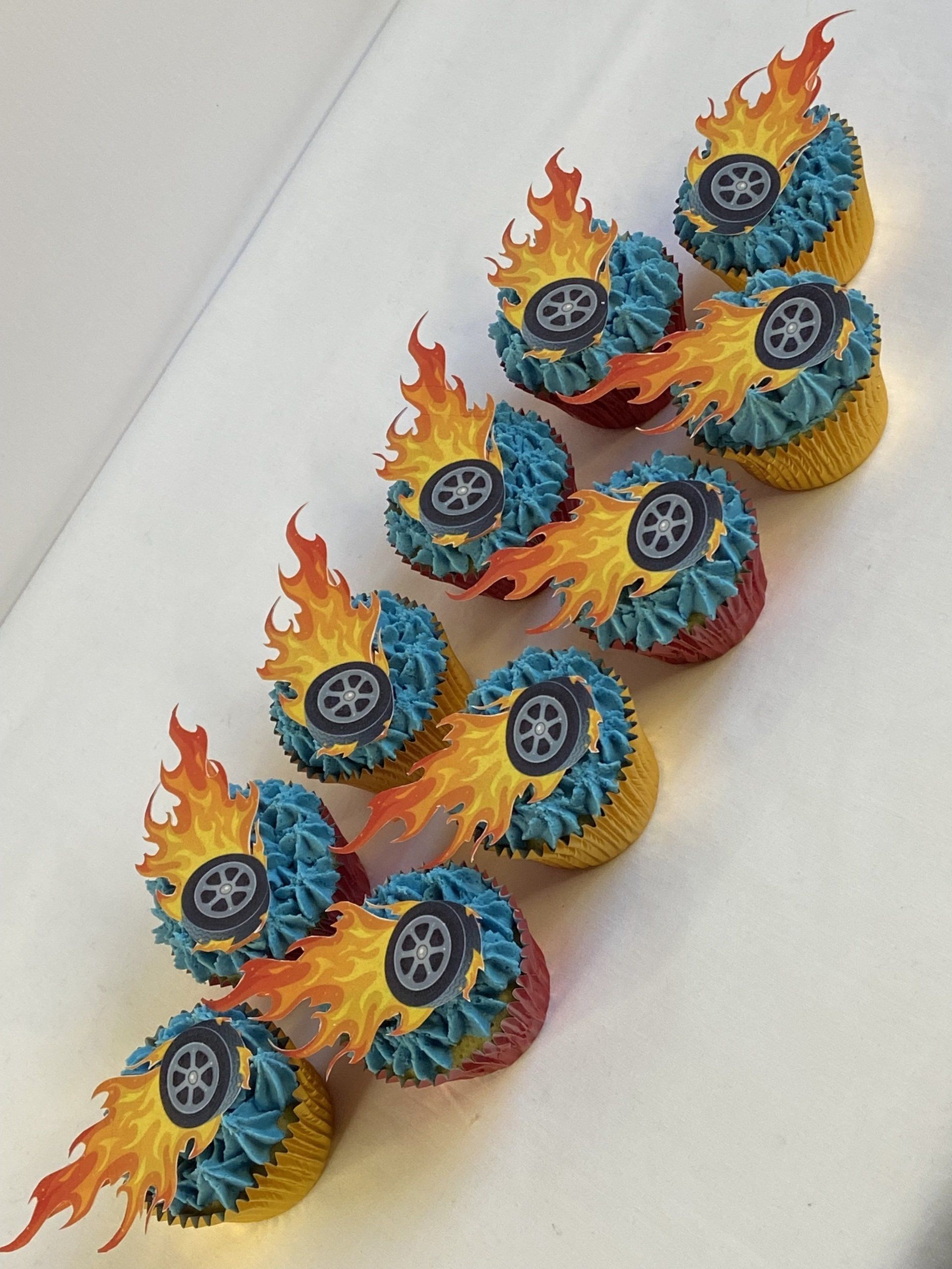 A row of cupcakes with wheels and flames on them