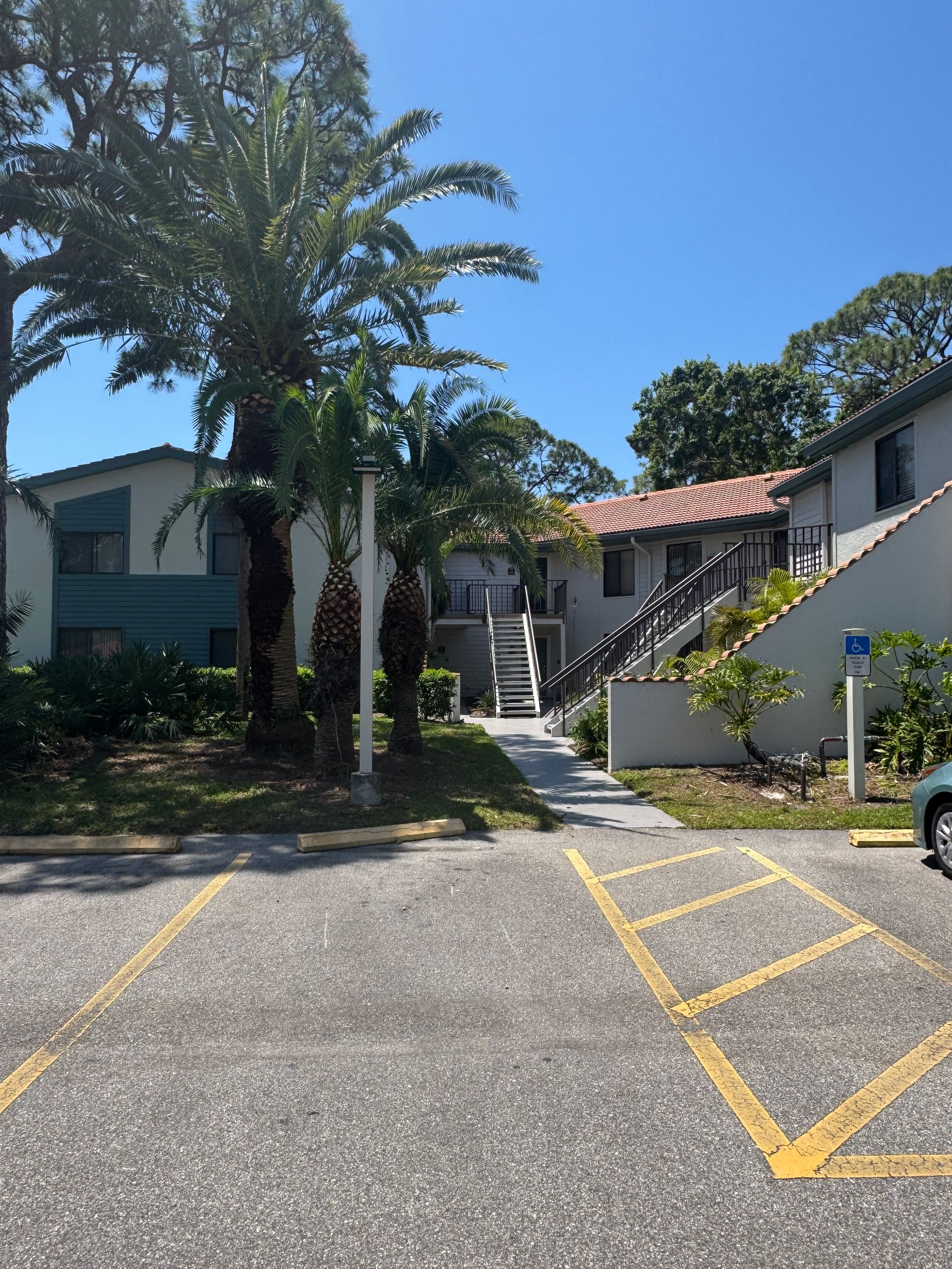 A car is parked in a handicapped parking spot in front of a building