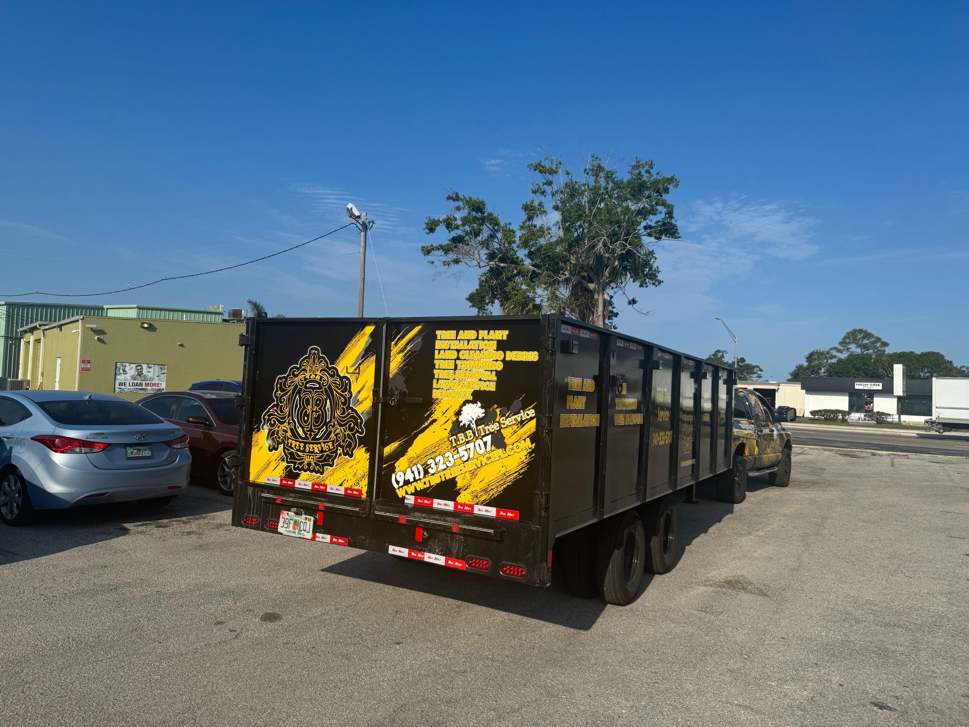 A black and yellow dump truck is parked in a parking lot.