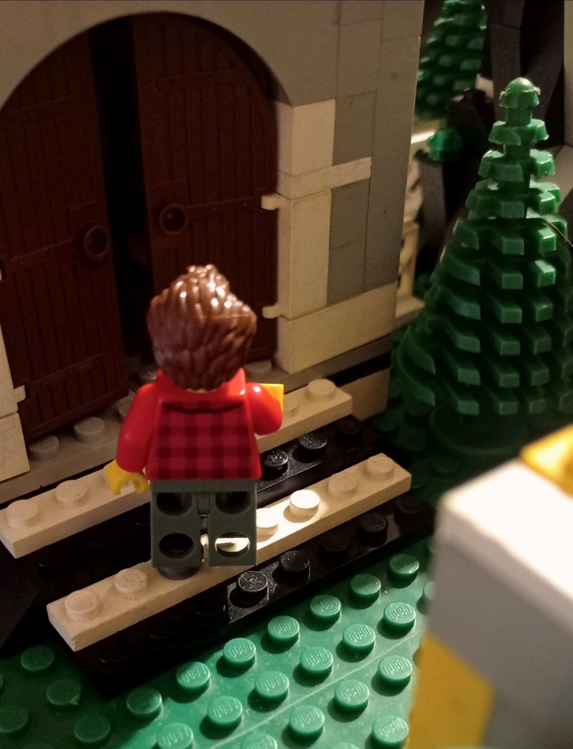 A lego figure is standing in front of a building