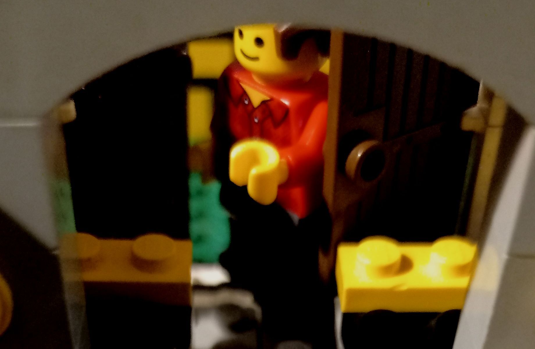 A lego figure is standing in a dark room