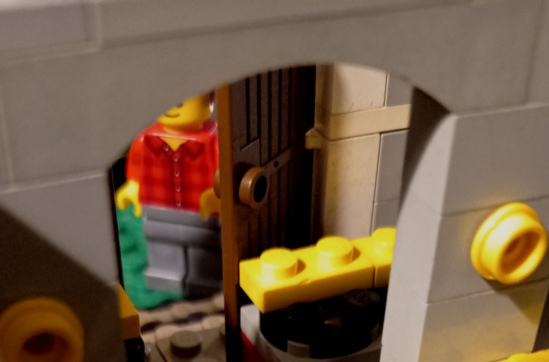 A lego figure is standing in a doorway in a building
