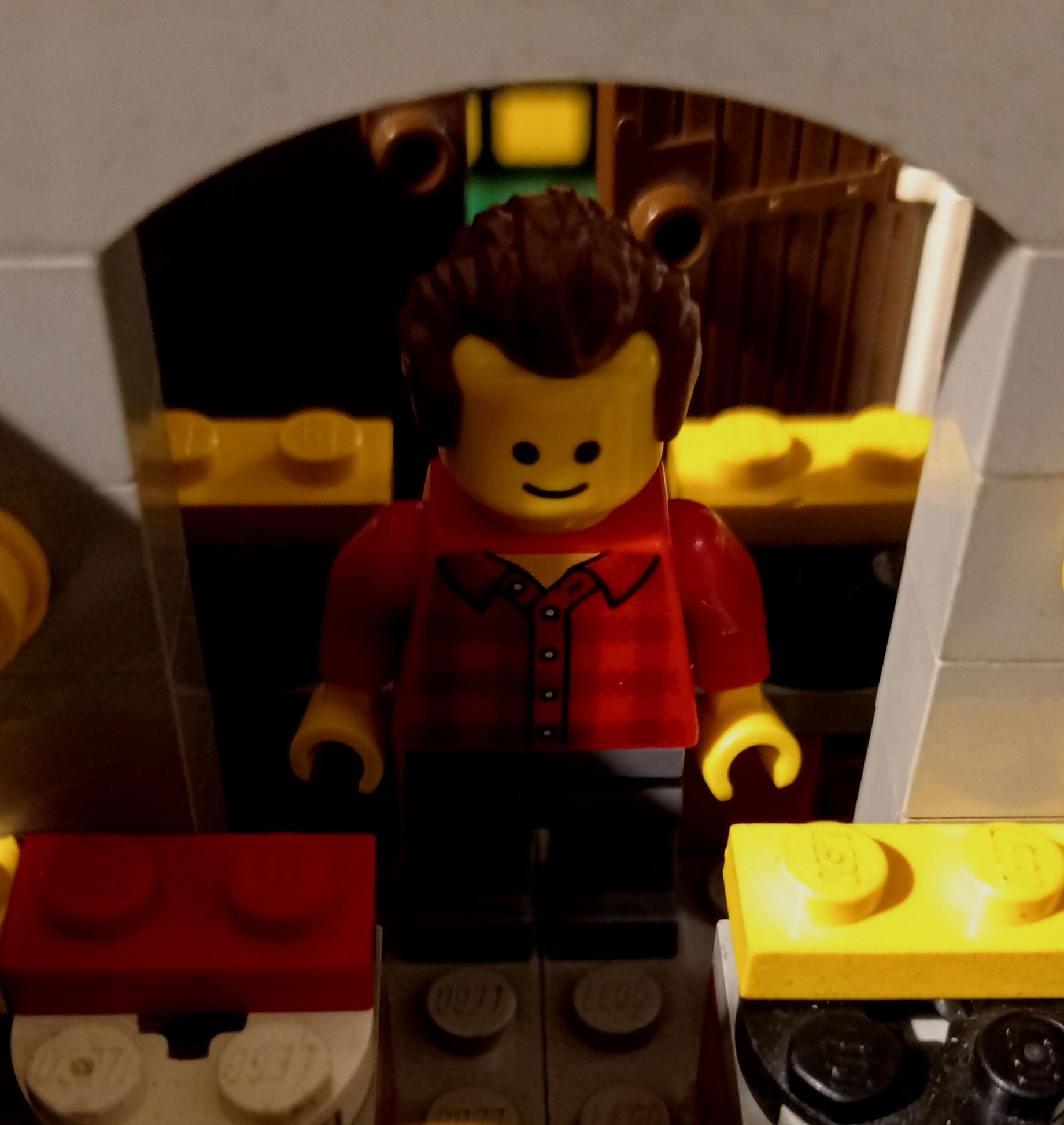 A lego man in a red shirt is standing in a room