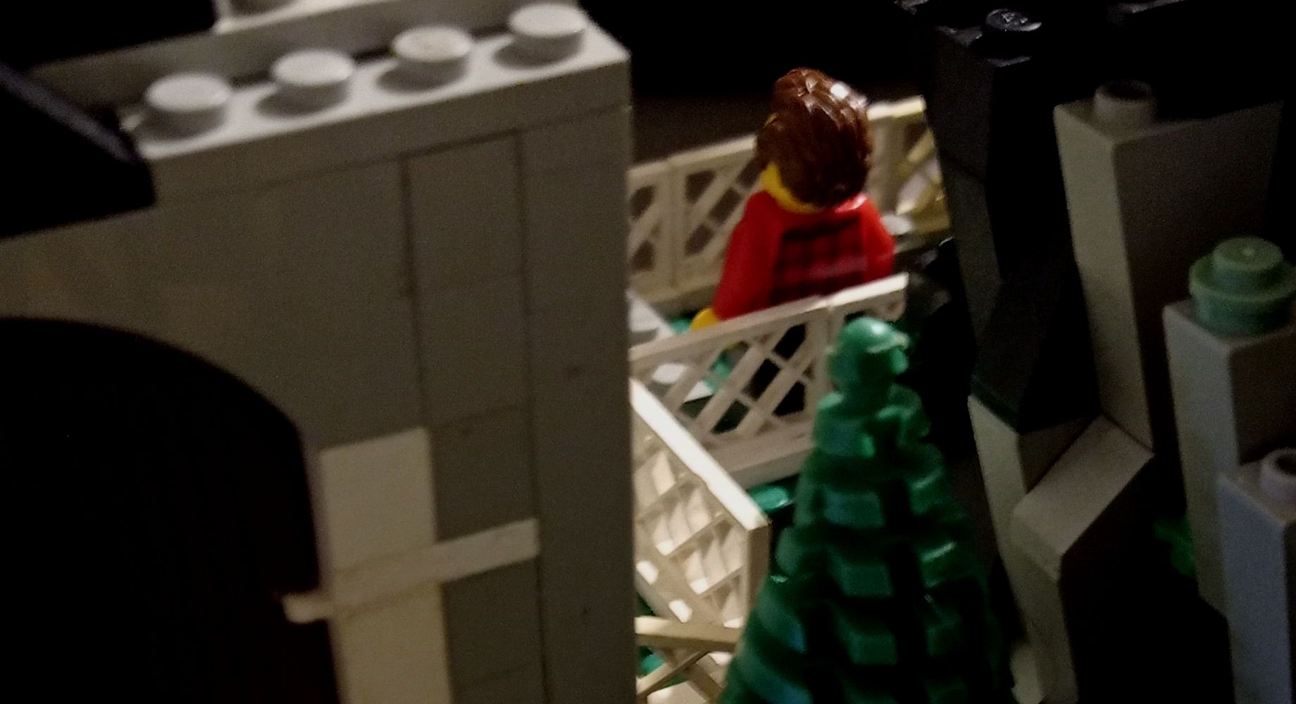 A lego figure is sitting in a basket next to a tree.