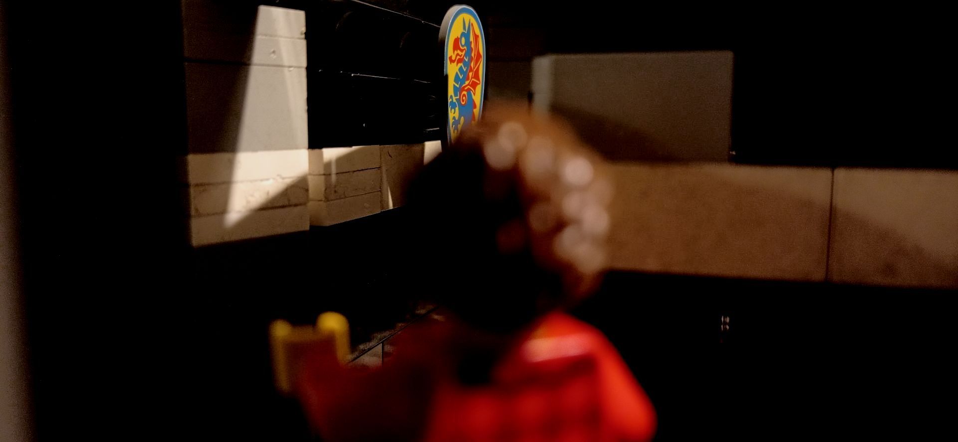 A person is holding a lollipop in their hand in a dark room.