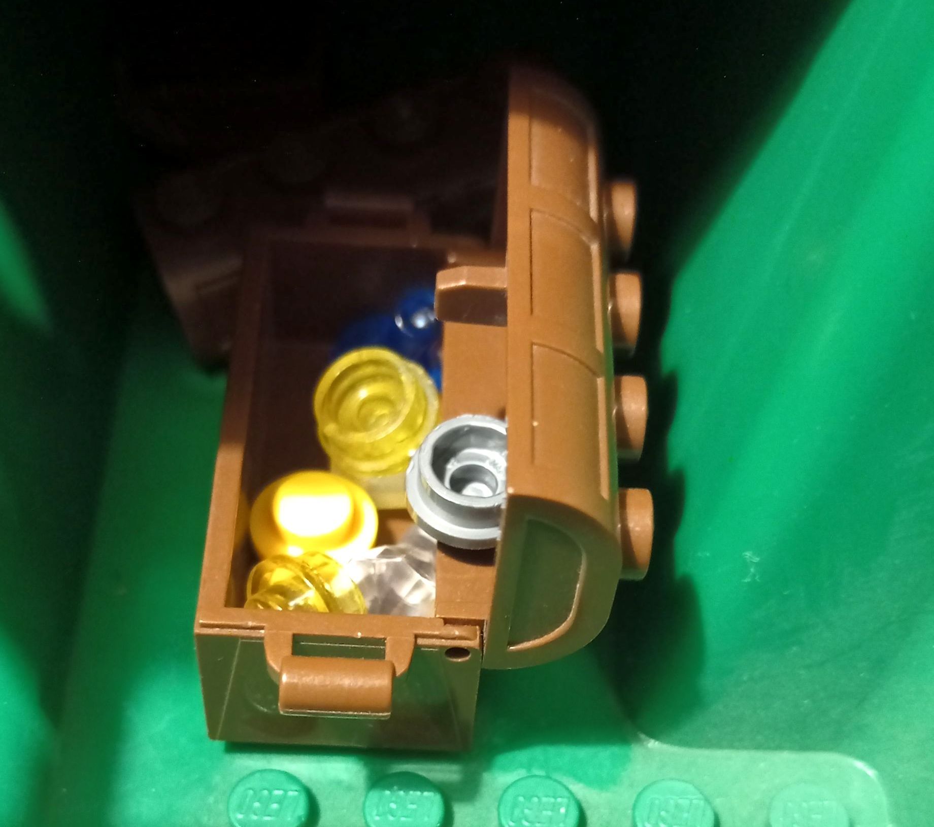 A lego treasure chest filled with gold and silver coins
