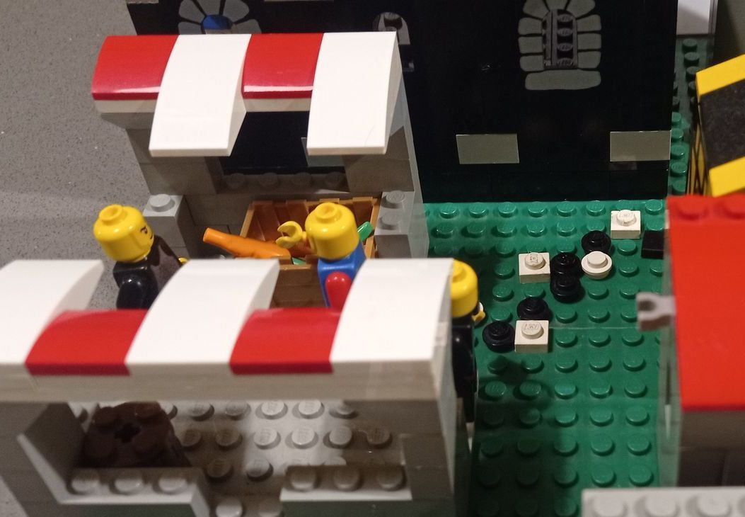 A lego model of a market with a red and white awning