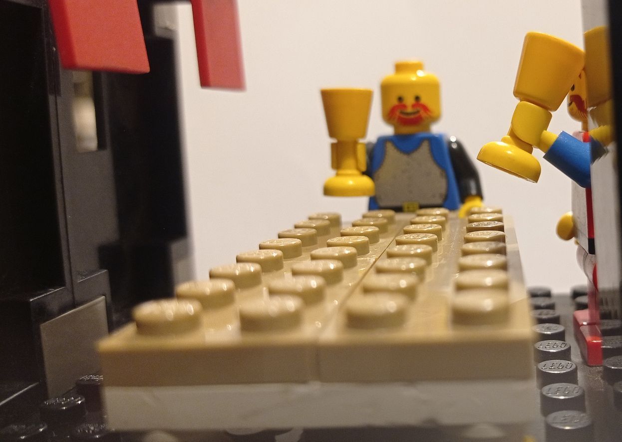A lego man is holding a trophy in front of a keyboard