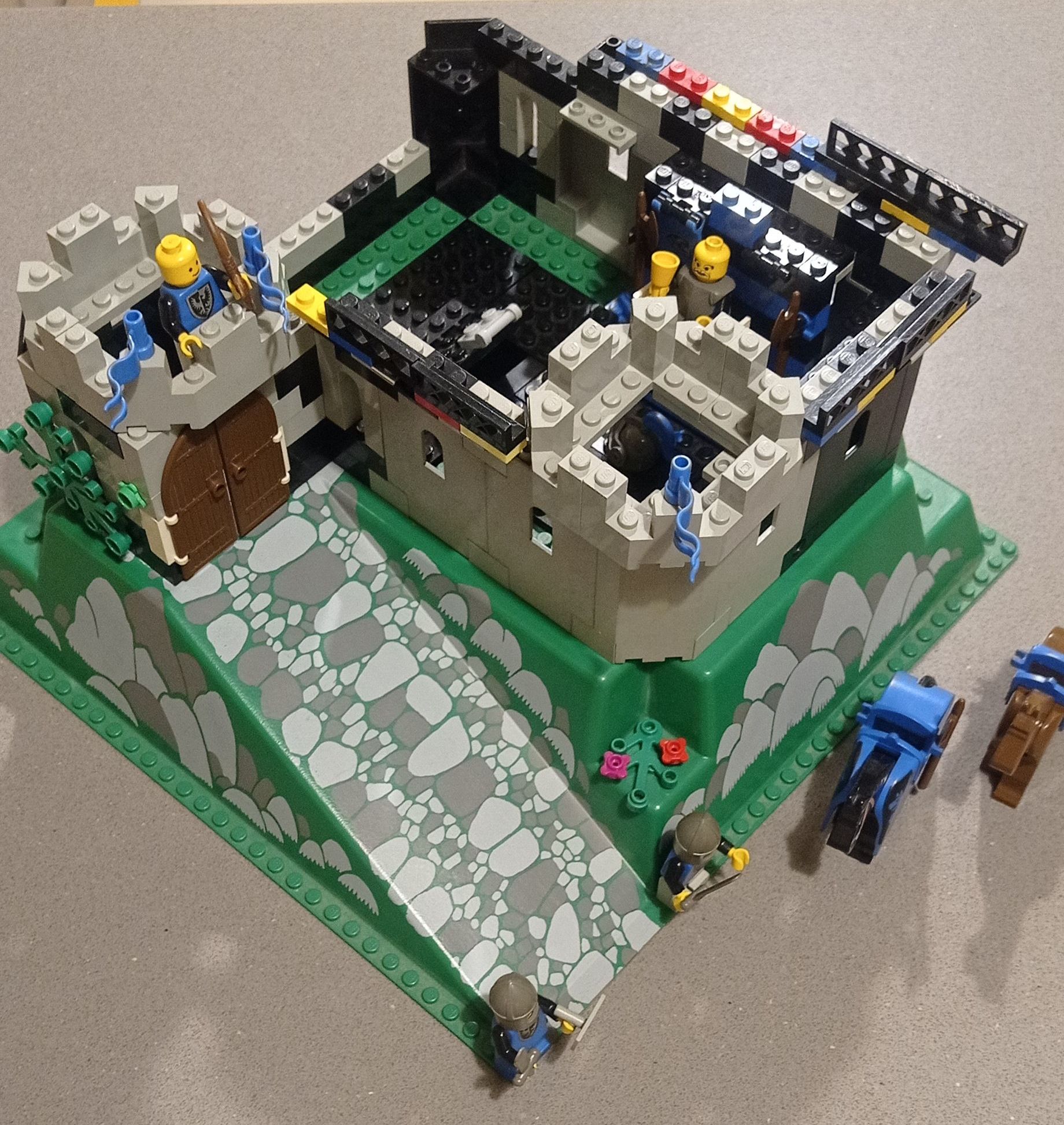 A lego castle sitting on top of a green platform